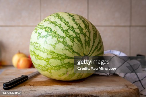 A whole watermelon on a cutting board. A whole watermelon on a cutting board.
