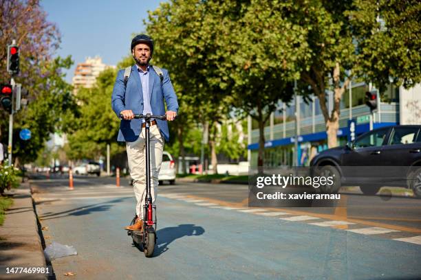 businessman commuting to work on electric push scooter - electric push scooter stock pictures, royalty-free photos & images