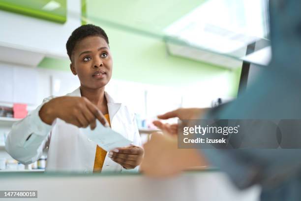 female pharmacist talking with customer - chemist shop stock pictures, royalty-free photos & images