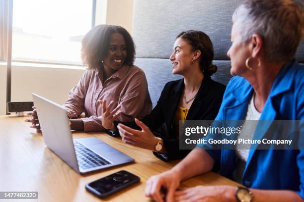 smiling group of diverse businesswomen talking during a meeting in an office cubicle - corporate modern office bright diverse imagens e fotografias de stock