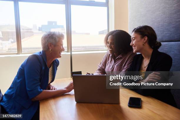 group of diverse businesswomen smiling and talking in an office cubicle - corporate modern office bright diverse imagens e fotografias de stock