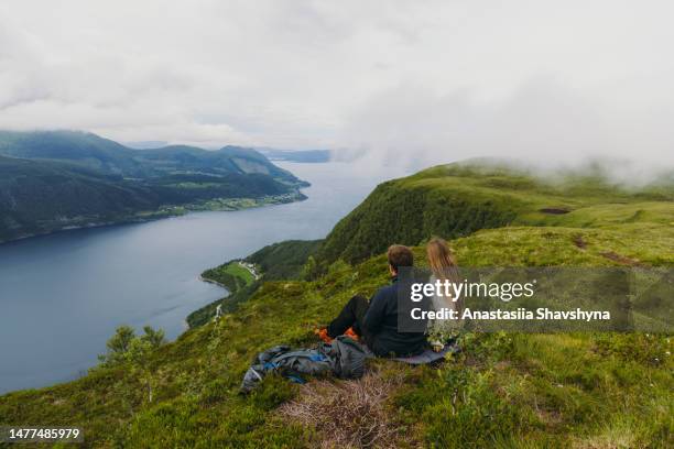 vista laterale della coppia felice che contempla la vista scenica del fiordo d'estate in norvegia - northern europe foto e immagini stock