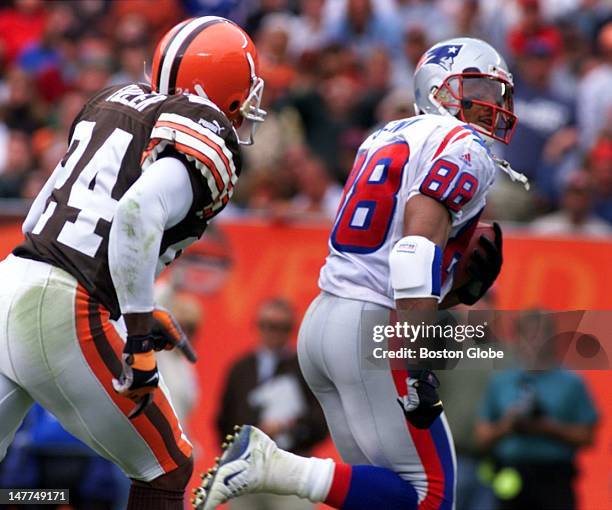 Patriots wide receiver Terry Glenn glances back as he gallops to the end zone after hauling in Drew Bledsoe's fourth quarter pass. Browns DB Corey...