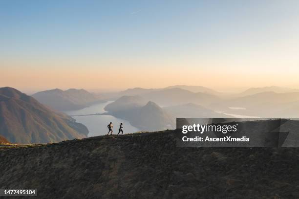 aerial view of trail runners ascending mountain ridge - athlete stock pictures, royalty-free photos & images