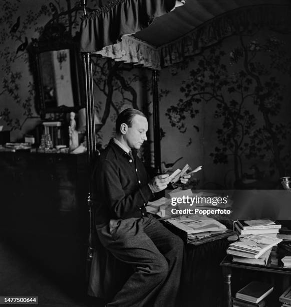 English playwright and actor Rodney Ackland seated with books and papers at his flat in the Albany apartment complex in Piccadilly, London on 10th...