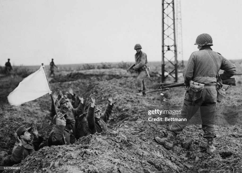A Surrender German soldiers raise their hands and a white flag as they surrender ...