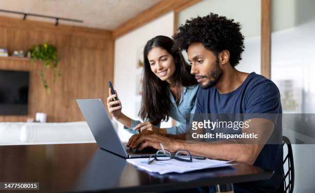 casal em casa pagando contas on-line usando um laptop - imposto - fotografias e filmes do acervo