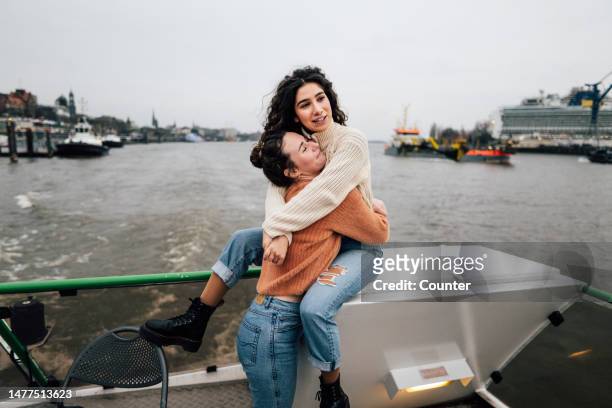 two friends riding on boat in harbour - travel stock-fotos und bilder