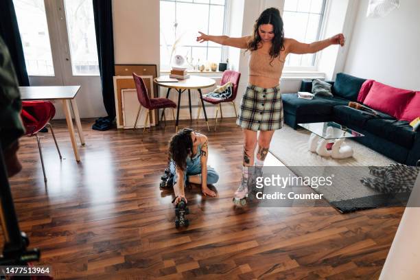two friends rollerskating at home - cool couple in apartment stock pictures, royalty-free photos & images