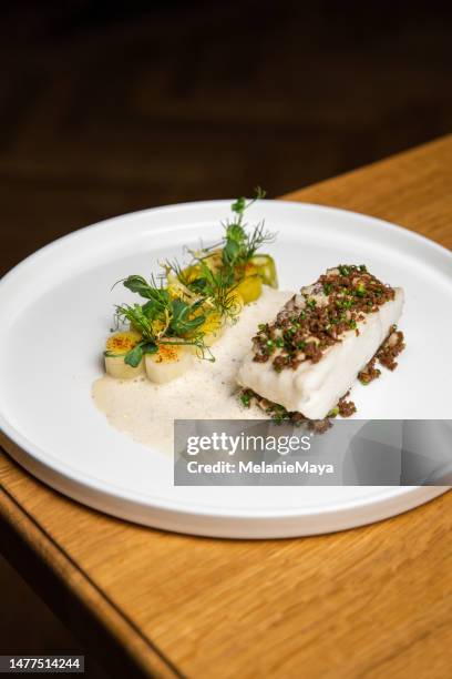 fish filet with leek vegetables and herbs at gourmet michelin food restaurant - cod dinner stock pictures, royalty-free photos & images