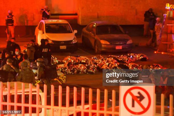 Rescuers work to take the injured and the corpses of the victims out of the premises after a fire at an immigration detention center in Northern...