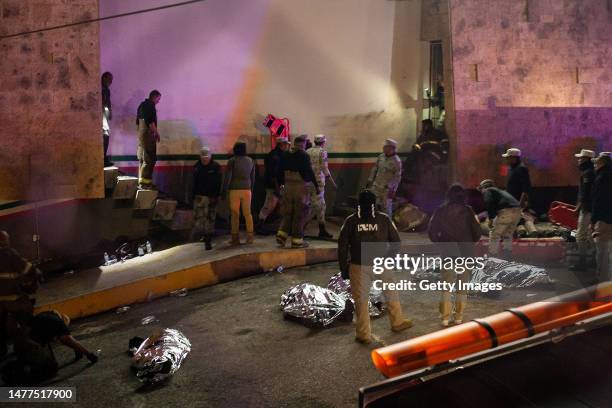 Rescuers work to take the injured and the corpses of the victims out of the premises after a fire at an immigration detention center in Northern...