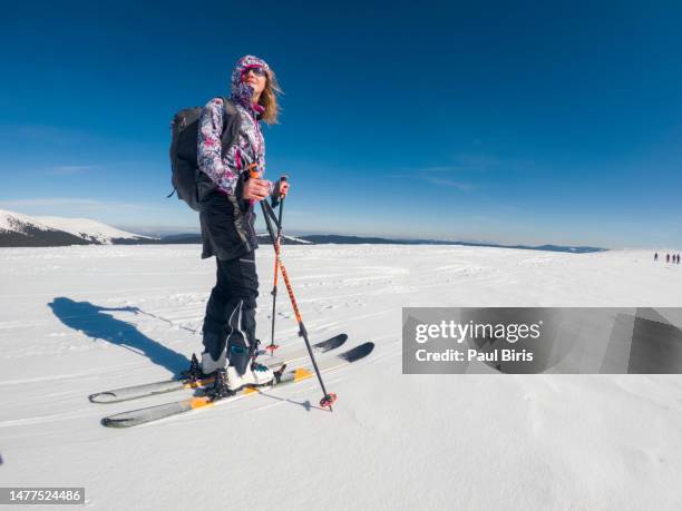 young caucasian woman ski touring on a sunny day. adventurous woman on skies - alps romania stock pictures, royalty-free photos & images