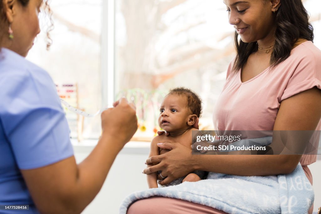 New Mom Holds Cute Alert Baby During Medical Exam High Res Stock Photo