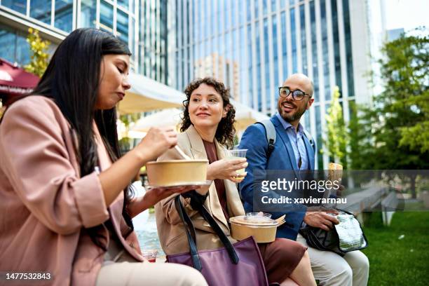 office workers eating lunch together - lunchpauze stockfoto's en -beelden