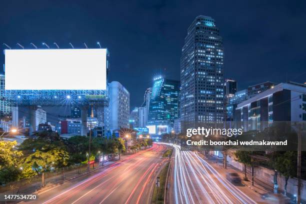 blank billboard on city street at night. - roadside advertising signs photos et images de collection
