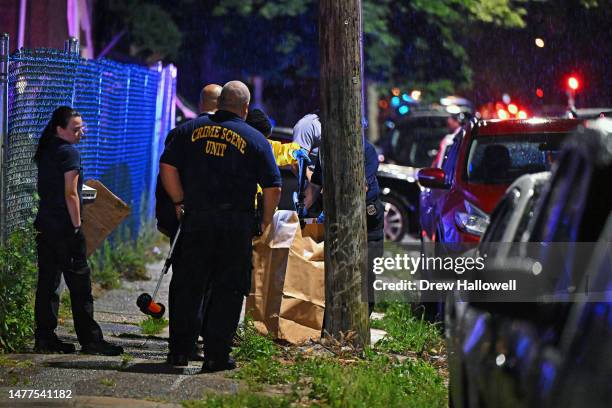 UPHILADELPHIA, PENNSYLVANIA Police place a rifle in a bag on the scene of a shooting on July 3, 2023 in Philadelphia, Pennsylvania. Early reports say...