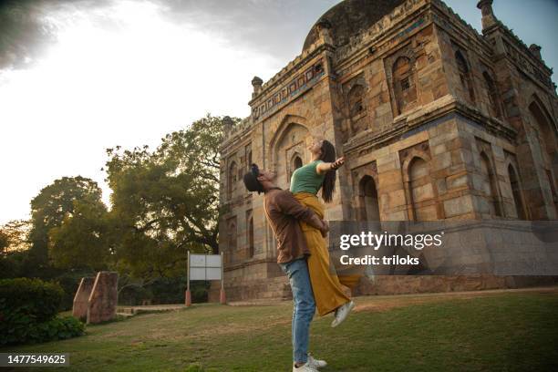 happy man lifting up his girlfriend in the air - india couple lift stock pictures, royalty-free photos & images