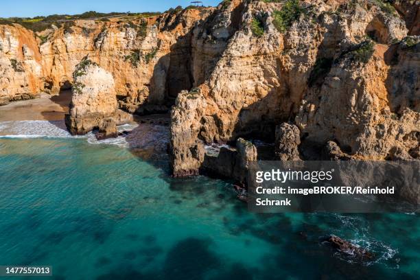 praia da marinha, rocks and cliffs, steep coast in the algarve, portugal - algarve stock-grafiken, -clipart, -cartoons und -symbole
