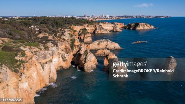 stockillustraties, clipart, cartoons en iconen met praia da marinha, rocks and cliffs, steep coast in the algarve, portugal - faro