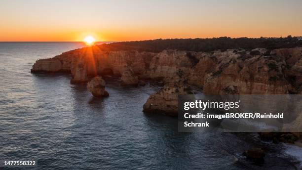 sunset at praia da marinha, rocks and cliffs, steep coast in the algarve, portugal - algarve portugal stock-grafiken, -clipart, -cartoons und -symbole