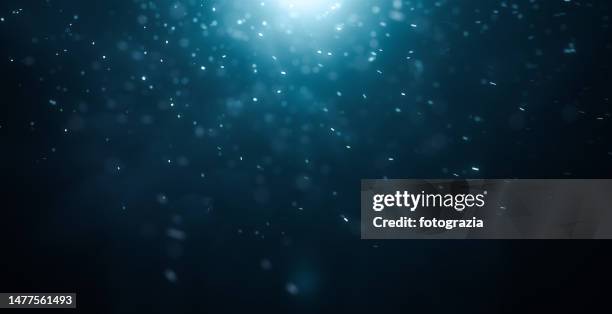 defocused particles against dark background - funkenflug stock-fotos und bilder