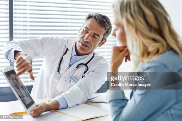 doctor showing digital tablet to woman in hospital - doctor bildbanksfoton och bilder