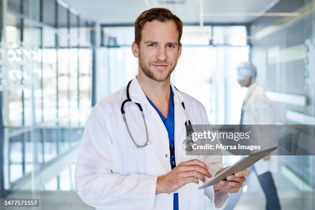 confident doctor using tablet pc in hospital - health doctor stock pictures, royalty-free photos & images