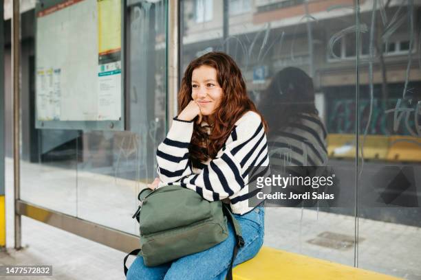 redhead woman on a bus stop - waiting bus stock pictures, royalty-free photos & images