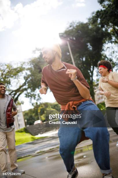 man dancing hip hop at the park with friends - funk music stock pictures, royalty-free photos & images
