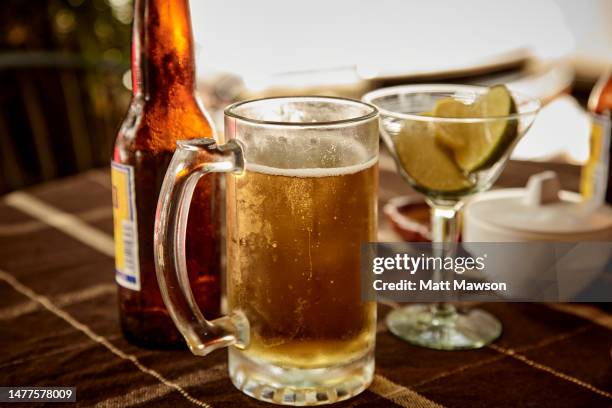 a frosty glass of beer on a table outside a mexican bar - jarro loiça imagens e fotografias de stock
