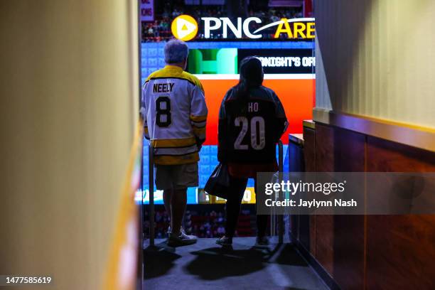 Carolina Hurricane fan and Boston Bruins fan look on before the first period of the game against the Boston Bruins at PNC Arena on March 26, 2023 in...