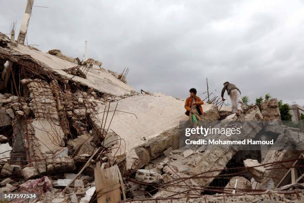 Boys walk amongst the rubble of a building destroyed in past aerial strikes carried out by warplanes from a coalition led by Saudi Arabia, as Yemen...