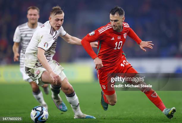 Kristers Tobers of Latvia is challenged by Aaron Ramsey of Wales during the UEFA EURO 2024 qualifying round group D match between Wales and Latvia at...