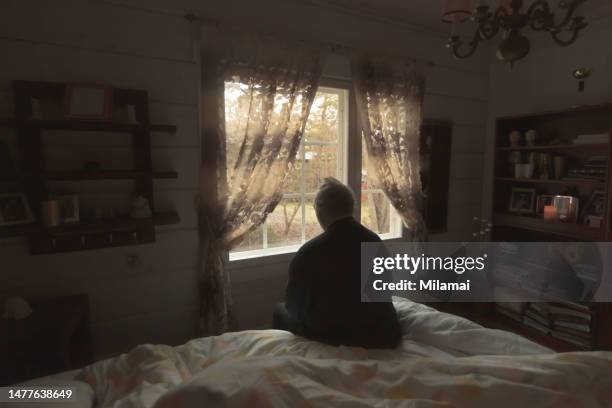 lonely senior man looking out of window - fat man sitting stock pictures, royalty-free photos & images