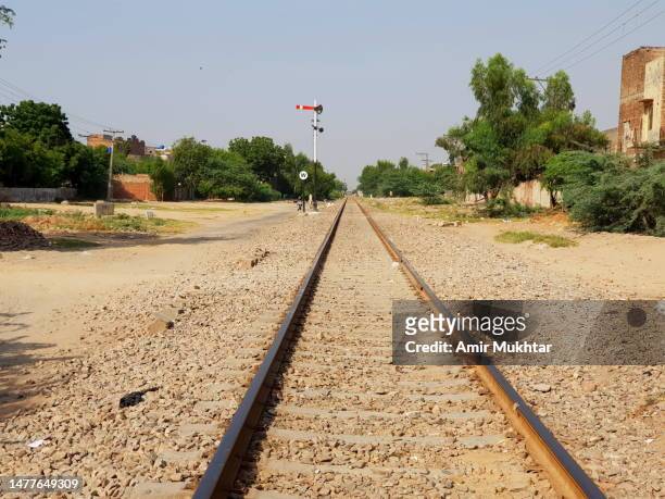 old style railway signal and an empty railroad track passing through rural area of pakistan. - punjab pakistan stockfoto's en -beelden