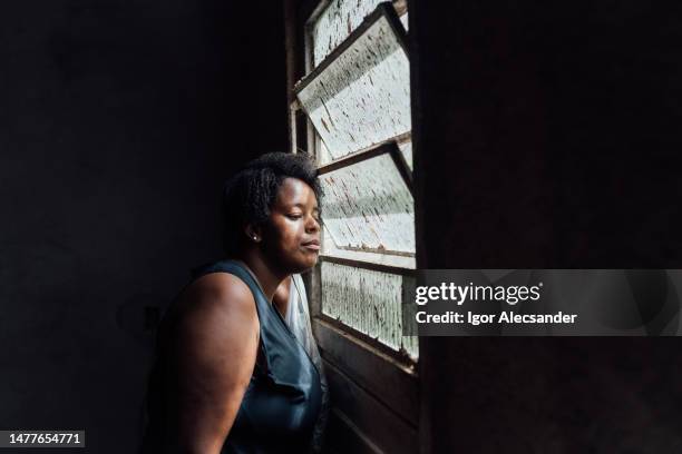 woman looking in the windowpane - zuid amerikaanse volksstammen stockfoto's en -beelden