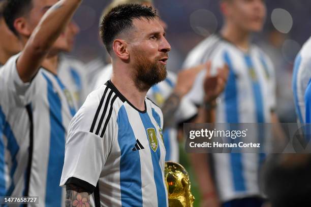 Lionel Messi of Argentina celebrates with the FIFA World Cup trophy during the World Champions' celebrations after an international friendly match...