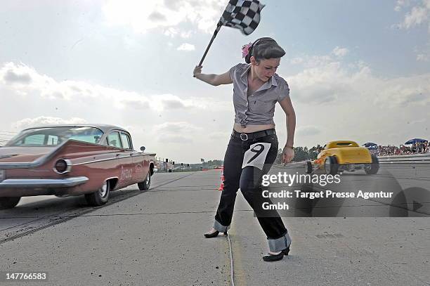 Starter girl starts a race over a 150 meter long short sprint track. Many thousand oldtimer and rock and roll enthusiasts attend the 'Roadrunners...