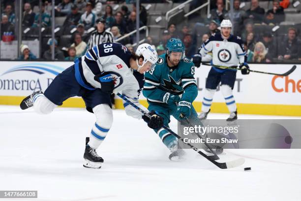 Morgan Barron of the Winnipeg Jets and Jeffrey Viel of the San Jose Sharks go for the puck in the first period at SAP Center on March 28, 2023 in San...
