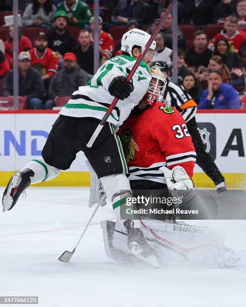 Luke Glendening of the Dallas Stars collides with Alex Stalock of the Chicago Blackhawks after scoring a goal during the third period at United...