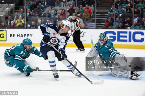 Logan Couture and James Reimer of the San Jose Sharks stop Kyle Connor of the Winnipeg Jets from scoringin the third period at SAP Center on March...