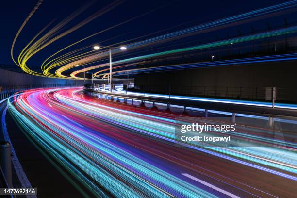 colorful light trails over a curved road - street light stock pictures, royalty-free photos & images