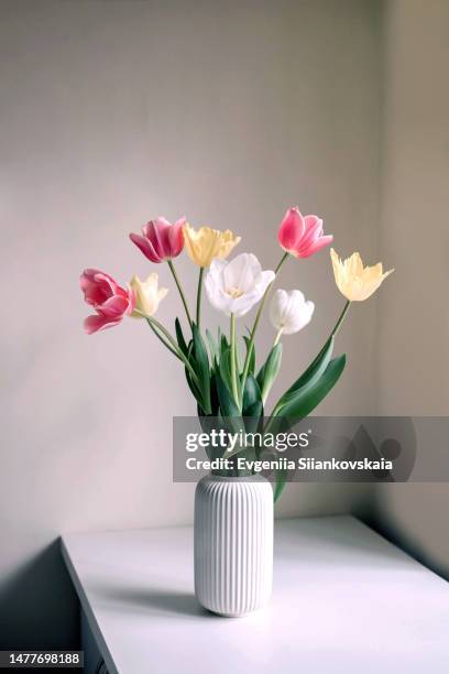 front view of bouquet with beautiful fresh spring tulips on the table at home. - vaas stockfoto's en -beelden