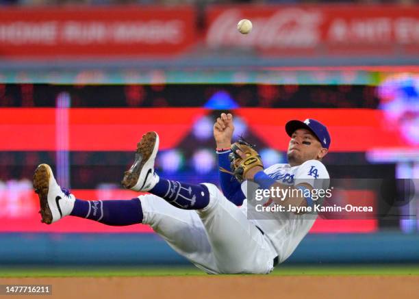 Miguel Rojas of the Los Angeles Dodgers fields a ball hit by Nick Gonzales of the Pittsburgh Pirates but it popped out of his hand as he attempted to...