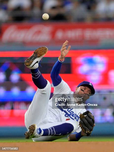 Miguel Rojas of the Los Angeles Dodgers fields a ball hit by Nick Gonzales of the Pittsburgh Pirates but it popped out of his hand as he attempted to...