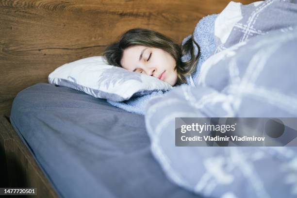 young woman sleeping blissfully - girl in her bed stock pictures, royalty-free photos & images