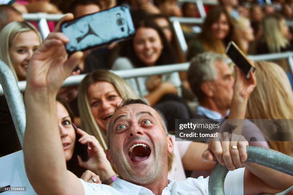 People taking a selfies at a footbal match
