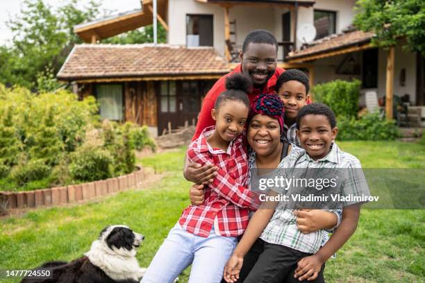 eine afroamerikanische familienumarmung im garten - jamaikanischer abstammung stock-fotos und bilder