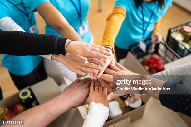 volunteers hands stacking in a circle - charity and relief work stock pictures, royalty-free photos & images